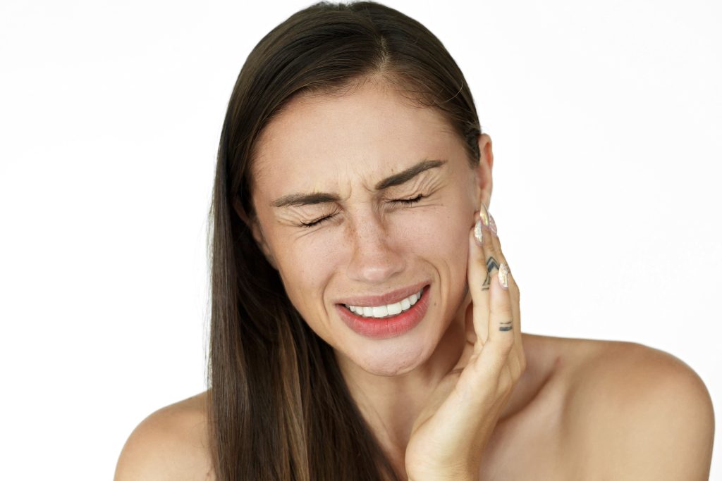 Desvendando os mistérios da DTM: Entenda o que é e como lidar com a Disfunção Temporomandibular 2 a mulher segura os dedos na bochecha mostrando dor de dente 1